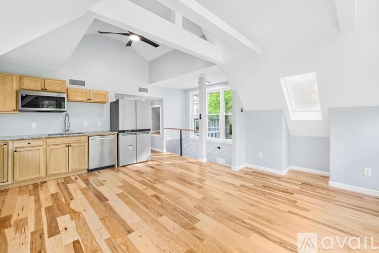 A kitchen with wooden floors and a ceiling fan.