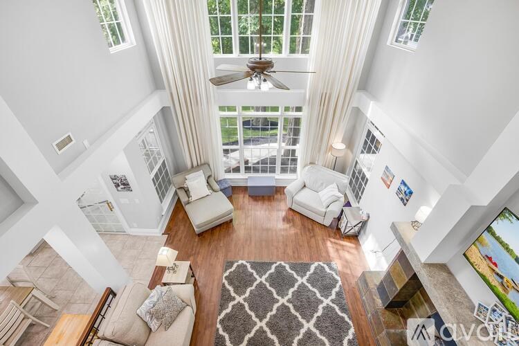 A living room with a rug on the floor and a television on the right side.