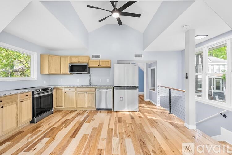 A kitchen with wooden floors and a ceiling fan.