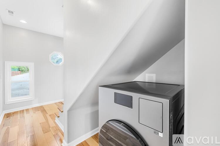A modern kitchen with a wood floor and a stainless steel dishwasher.