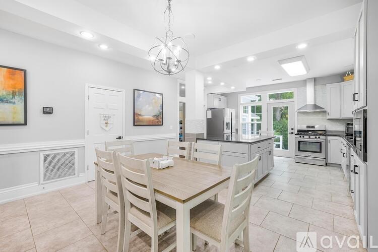 A well-lit, spacious kitchen and dining area with a wooden table and chairs.