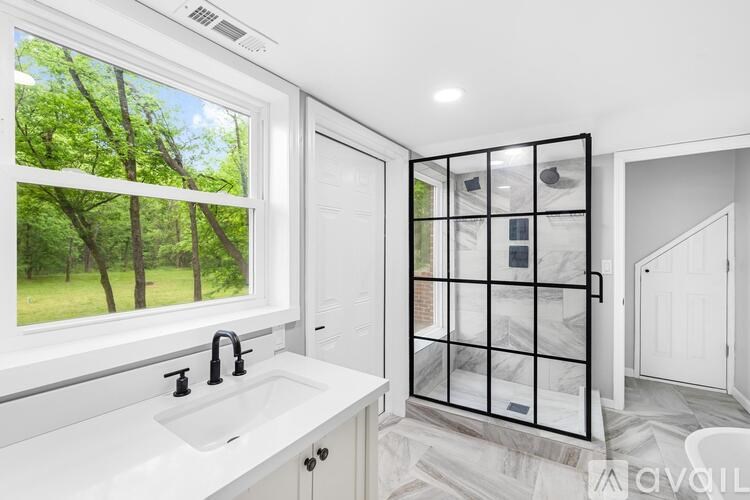 A bathroom with a large window and a marble floor.