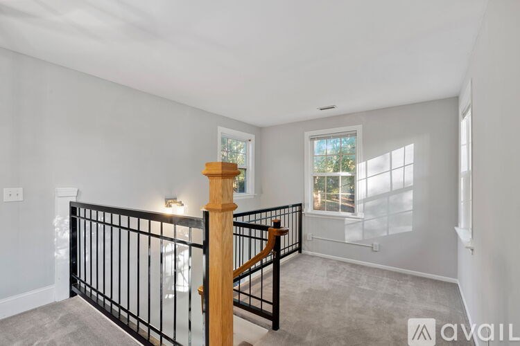 A spacious room with a staircase leading to the second floor.