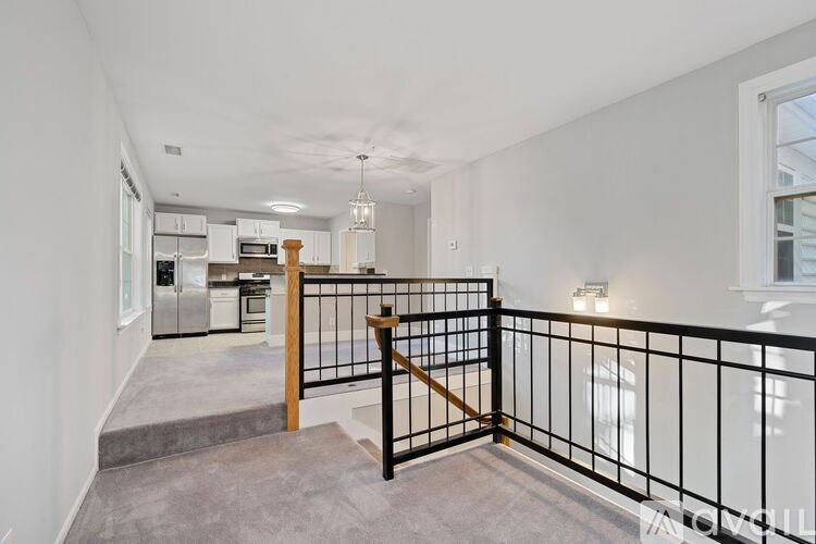 A well-lit, spacious apartment with a kitchen in the background.