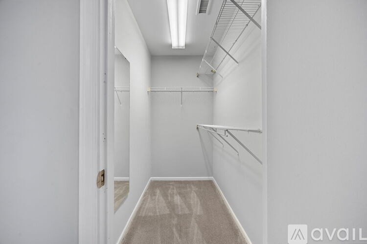 A long hallway with a carpeted floor and white walls.