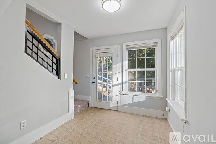 A room with a window and a door leading to a balcony.
