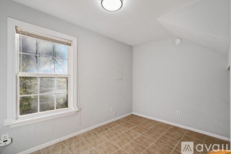 A room with a window and tiled floor.