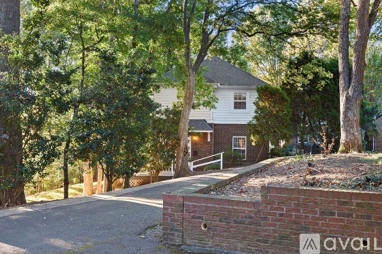 A house is surrounded by trees and has a driveway.