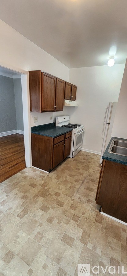 A kitchen with wooden cabinets and a tiled floor.