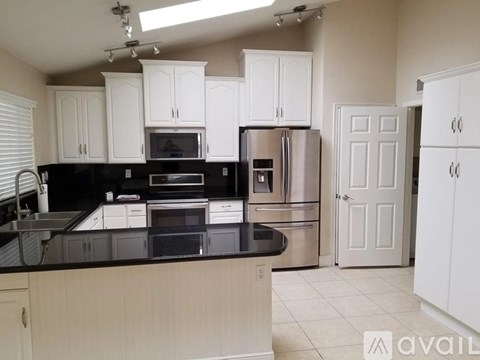 A kitchen with black countertops and white cabinets.