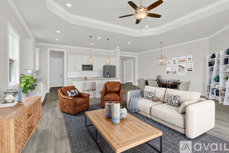 A living room with a white couch, brown armchair, and a wooden coffee table.