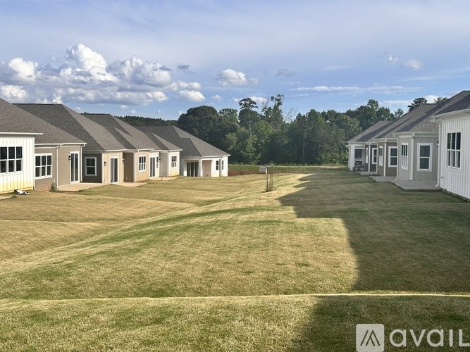 A row of houses with a grassy field in front.