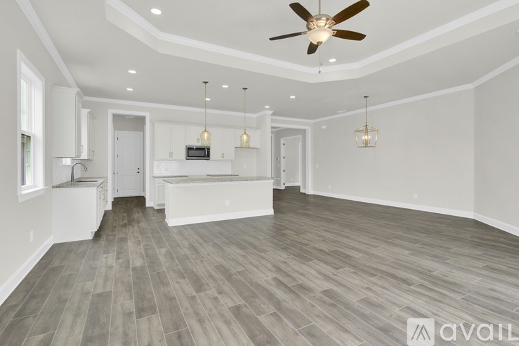 A spacious room with a ceiling fan and wooden flooring.