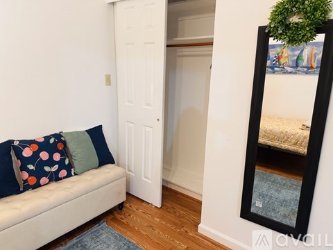 A living room with a couch and a mirror.