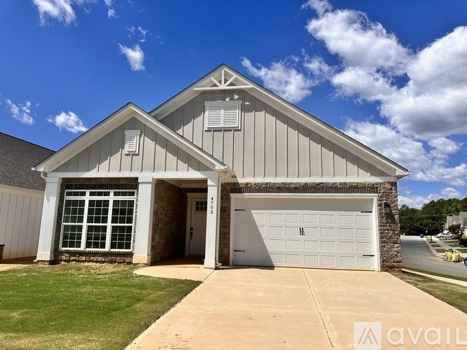 A house with a garage and a driveway in front.