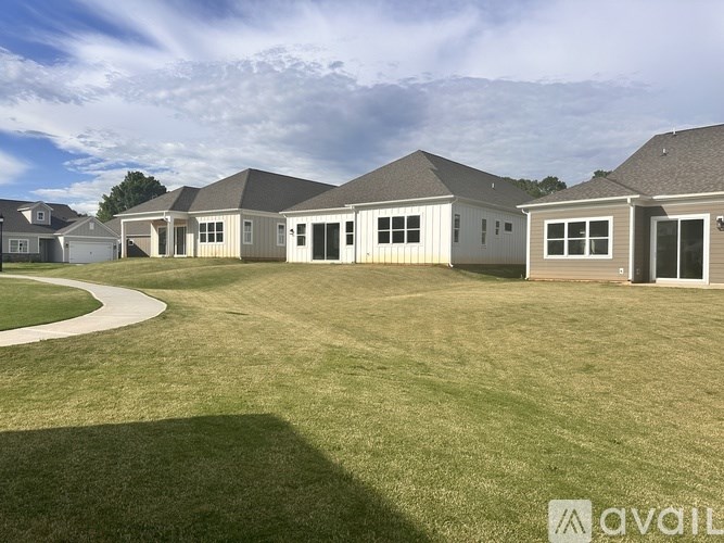 A row of houses with a grassy lawn in front.