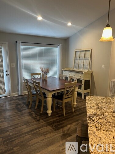 A dining room with a wooden table and chairs.