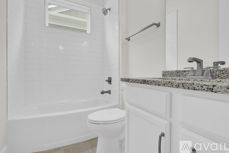 A white bathroom with a toilet, sink, and bathtub.