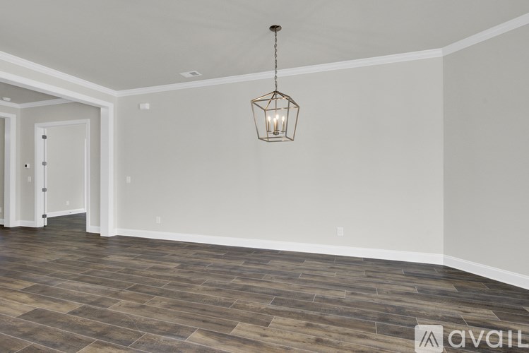 A room with a wooden floor and a hanging light fixture.