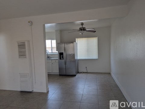 A kitchen with white cabinets and a stainless steel refrigerator.