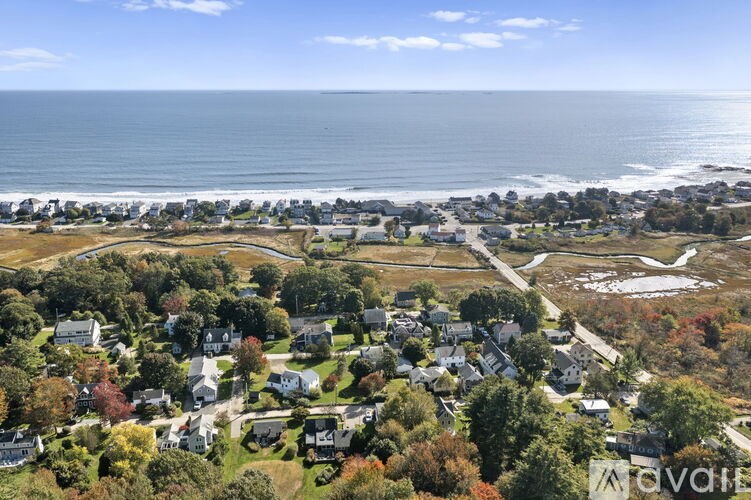 A bird's eye view of a coastal neighborhood with houses and trees.