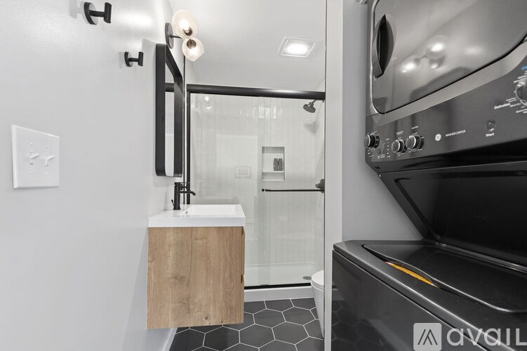 A modern kitchen with a black oven and a wooden sink cabinet.