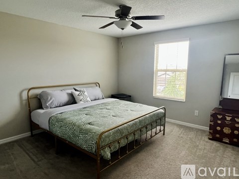 A bedroom with a bed, dresser, and window.