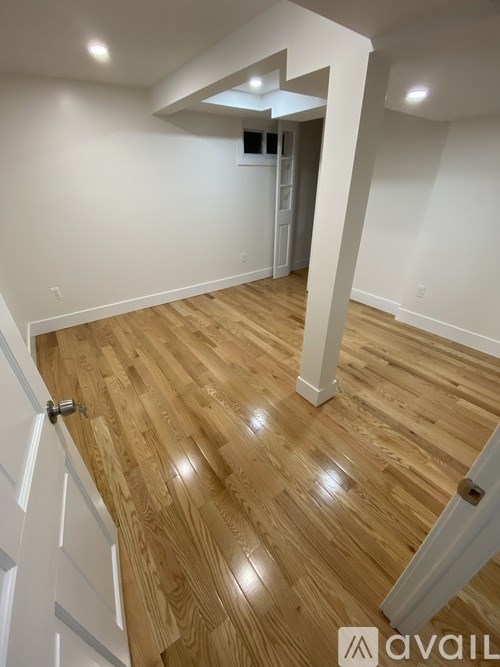 A room with wooden flooring and white walls.
