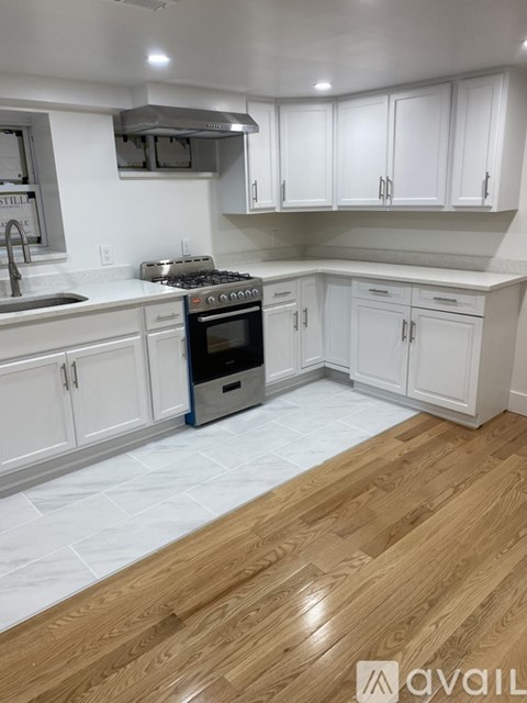 A kitchen with white cabinets and a black stove top oven.