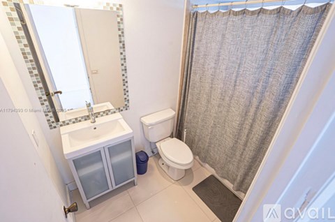 A bathroom with a toilet, sink, and shower curtain.