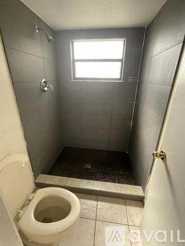 A small bathroom with a toilet and a window.