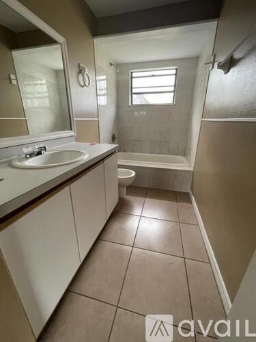 A bathroom with a sink, mirror, and shower.