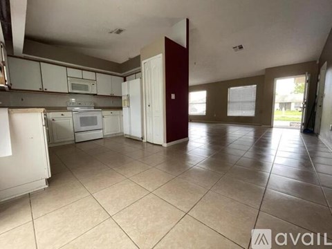 A kitchen with white appliances and a red door.