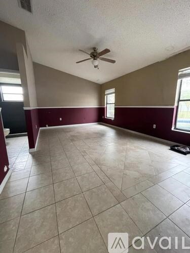 A room with a ceiling fan and tile flooring.