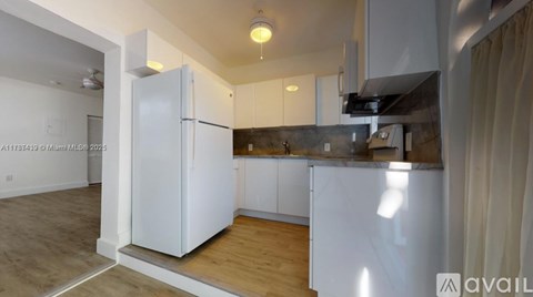A kitchen with white appliances and cabinets.