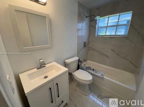 A bathroom with a sink, toilet, and bathtub.