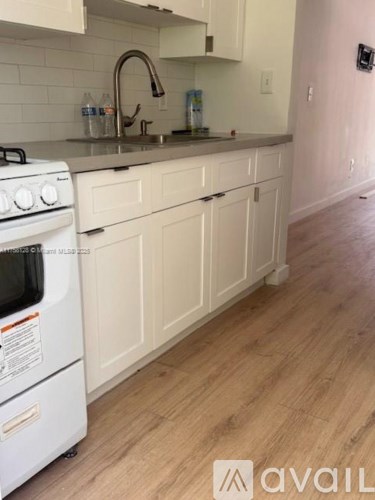 A kitchen with white cabinets and a white stove.