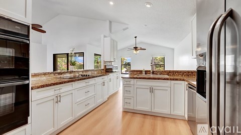 A modern kitchen with white cabinets and a wooden countertop.