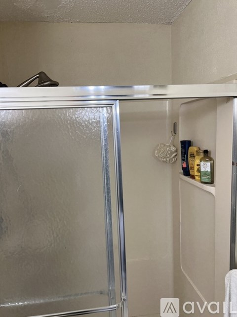 A small, white refrigerator with a glass door is in a kitchen.