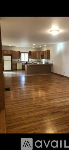 A kitchen with wooden floors and cabinets.