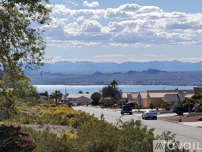 A street view of a residential area with cars driving on the road.