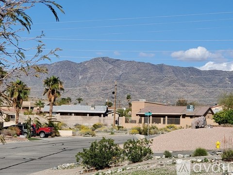 A desert landscape with a mountain in the background and a building in the foreground.