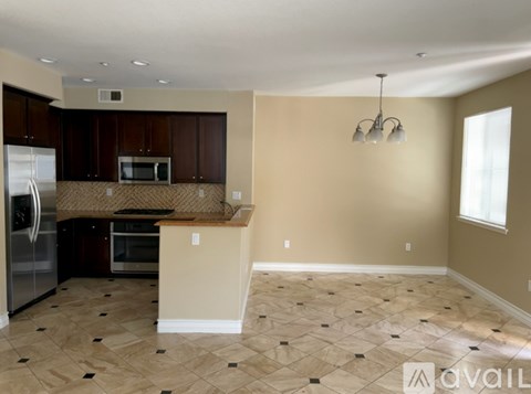A kitchen with a refrigerator, microwave, and oven.