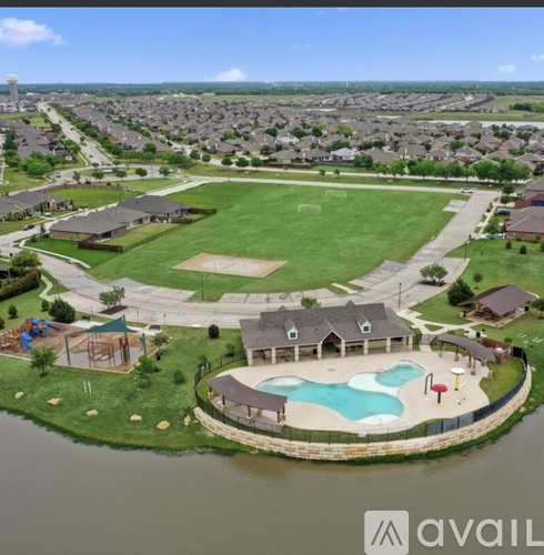 A bird's eye view of a residential area with a swimming pool and a baseball field.
