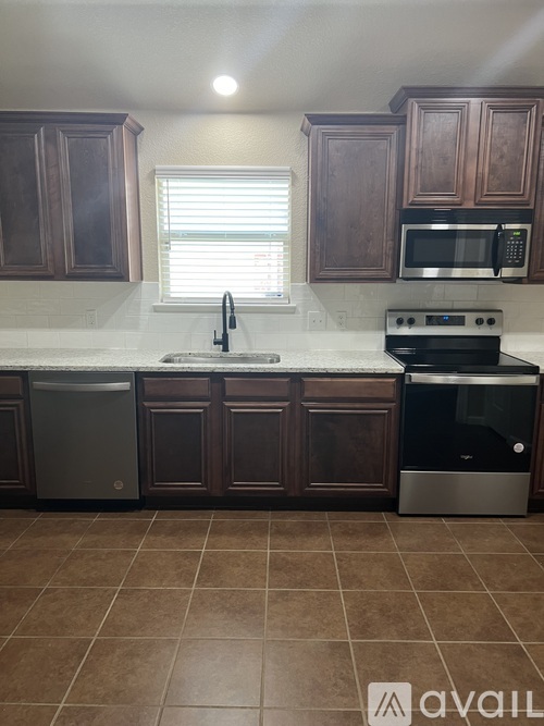 A kitchen with brown cabinets and a white countertop.
