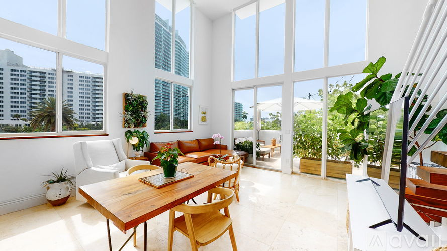 A dining room with a table and chairs and a view of the city.