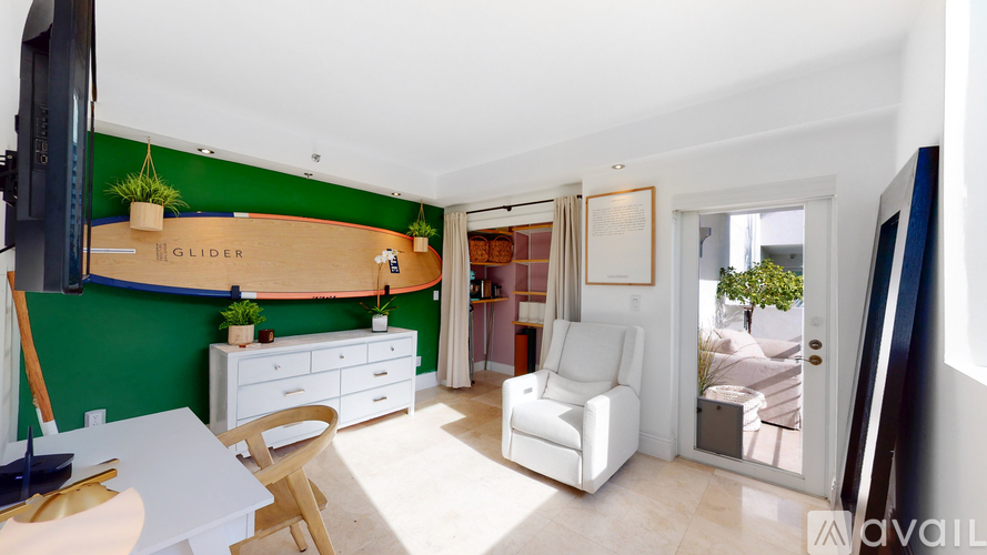 A living room with a white couch and a green wall.