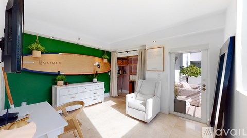 A living room with a white couch and a green wall.