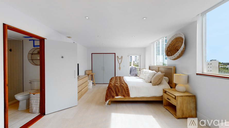 A bedroom with a large bed and a wooden headboard.