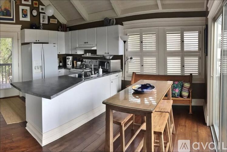 A kitchen with a table and chairs and a fridge.